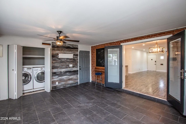 laundry area with brick wall, dark wood-type flooring, independent washer and dryer, and ceiling fan