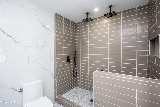 bathroom featuring a tile shower and toilet