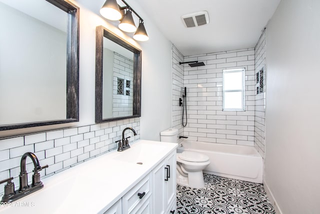 full bathroom with tile patterned flooring, backsplash, tiled shower / bath combo, vanity, and toilet