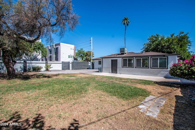 rear view of house with a lawn and a patio area