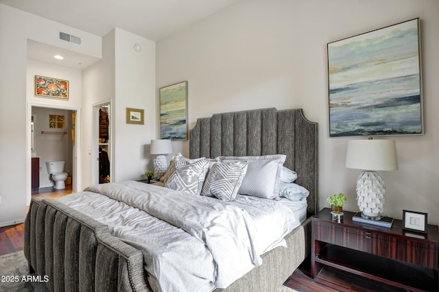 bedroom featuring ensuite bath, wood finished floors, and visible vents