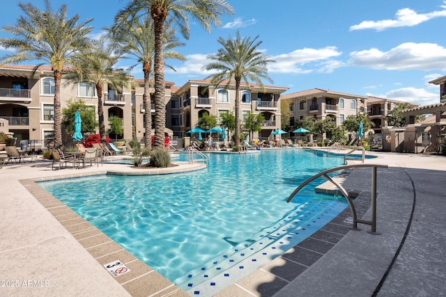 pool featuring a residential view, a patio, and fence