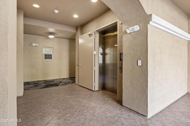 hallway with recessed lighting, elevator, and tile patterned floors