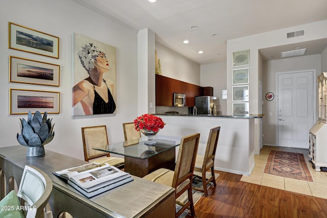 dining area featuring light wood-type flooring, baseboards, visible vents, and recessed lighting