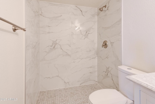 bathroom featuring a marble finish shower, vanity, and toilet