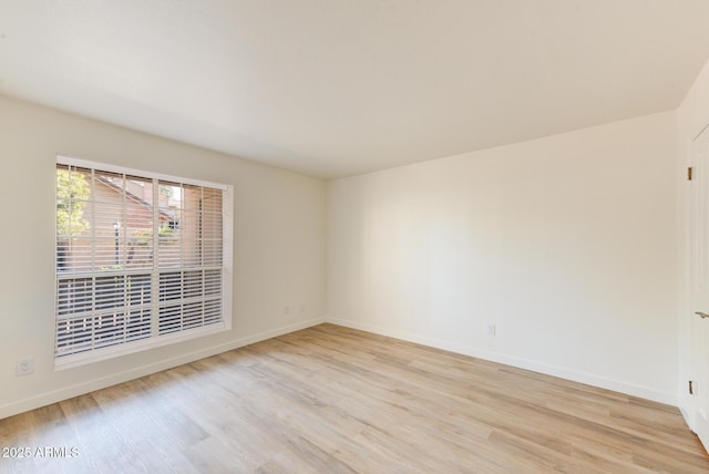 spare room with light wood-style flooring and baseboards