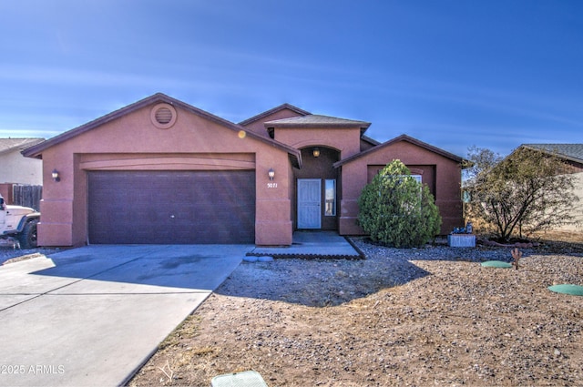 view of front facade featuring driveway, a garage, and stucco siding