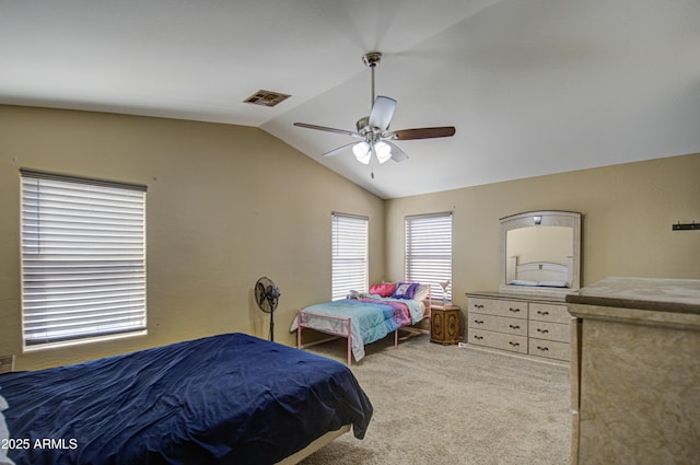 carpeted bedroom featuring visible vents, vaulted ceiling, and a ceiling fan