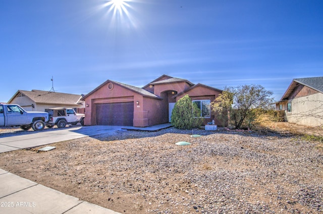 view of front of property featuring a garage, concrete driveway, and stucco siding