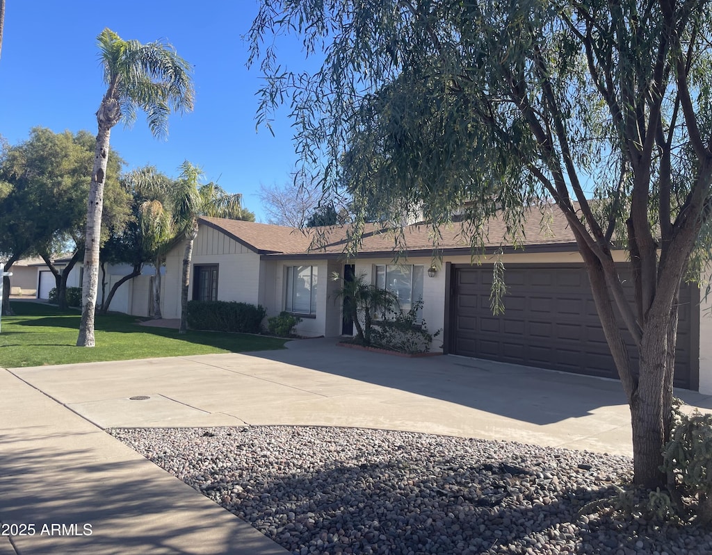 ranch-style house with a garage and a front yard