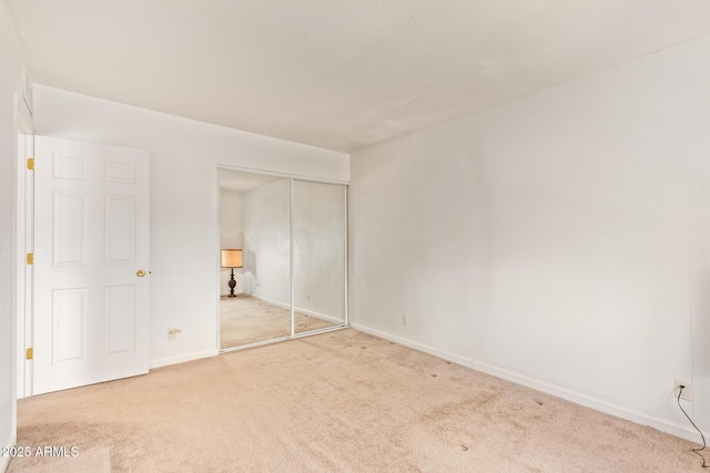 unfurnished bedroom featuring carpet floors, a closet, and baseboards