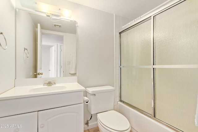 bathroom with vanity, toilet, and shower / bath combination with glass door