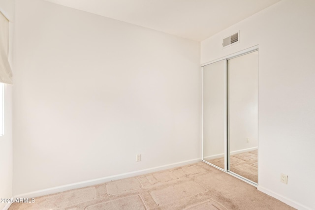 unfurnished bedroom featuring a closet, carpet flooring, and baseboards