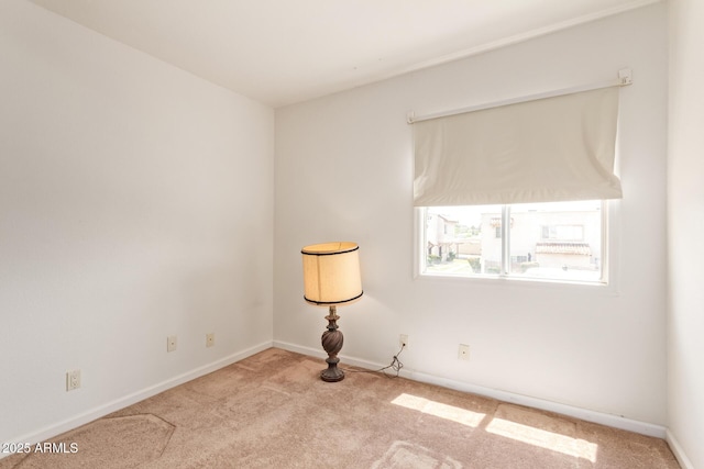 carpeted empty room featuring baseboards