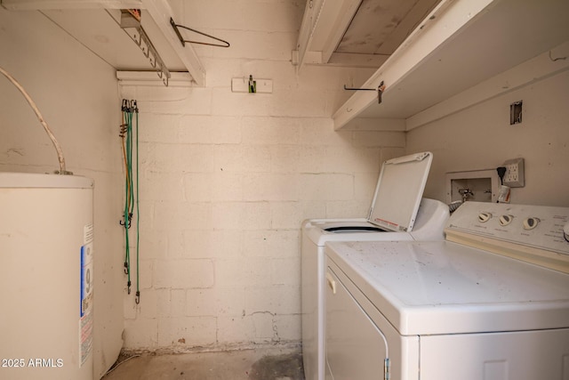 laundry room with electric water heater, washing machine and dryer, and concrete block wall