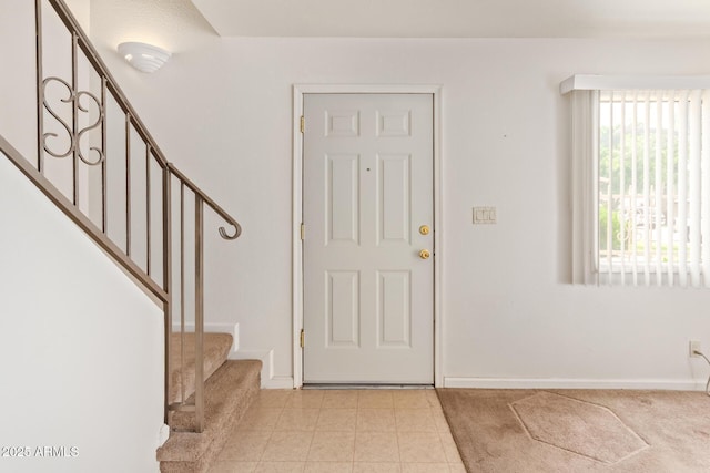 entryway with stairs, baseboards, and light tile patterned floors