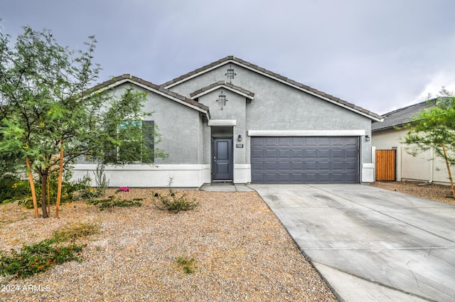 single story home with driveway, a tiled roof, an attached garage, and stucco siding