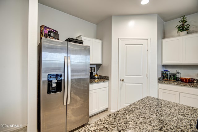 kitchen with white cabinets, dark stone counters, and stainless steel refrigerator with ice dispenser