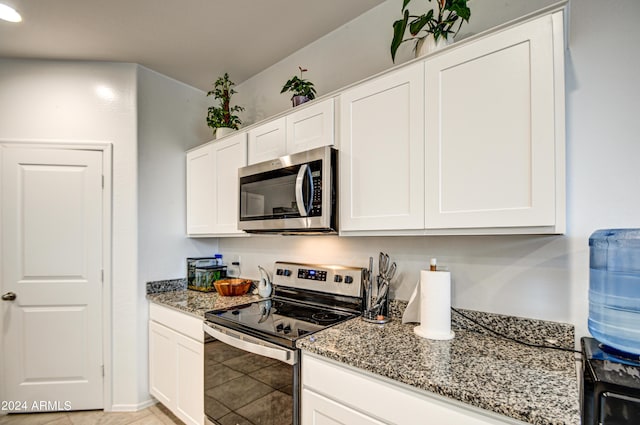 kitchen featuring light tile patterned floors, stainless steel appliances, white cabinetry, and light stone countertops