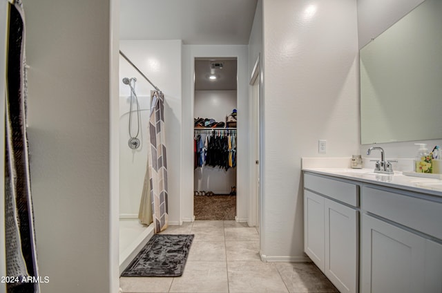 full bathroom featuring visible vents, a spacious closet, a stall shower, vanity, and tile patterned flooring