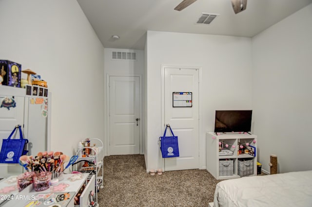 bedroom featuring freestanding refrigerator, visible vents, and carpet flooring