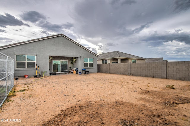 back of house with a fenced backyard and stucco siding