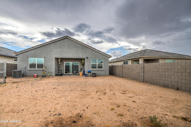 back of property featuring central air condition unit, a fenced backyard, and stucco siding