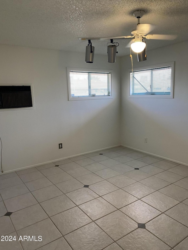 tiled spare room featuring ceiling fan and a textured ceiling