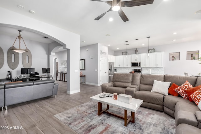 living room with ceiling fan and light wood-type flooring