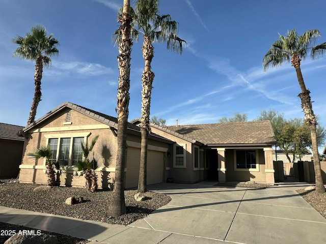 view of front facade featuring an attached garage, a tiled roof, and stucco siding