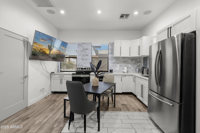 1807 E Campbell Ave, Phoenix, AZ 85016 - kitchen with appliances with stainless steel finishes, white cabinetry, light countertops, backsplash, and recessed lighting