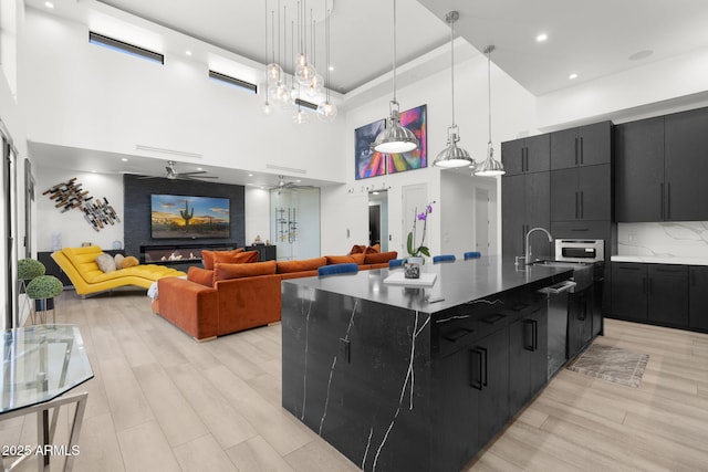 1807 E Campbell Ave, Phoenix, AZ 85016 - kitchen with a towering ceiling, dark cabinets, dishwasher, a large island, and light wood-type flooring