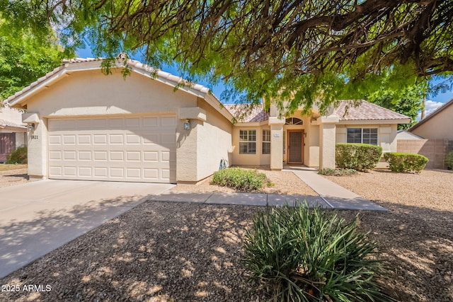 ranch-style home with a tiled roof, a garage, driveway, and stucco siding