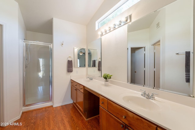 bathroom featuring wood finished floors, visible vents, a sink, and a stall shower