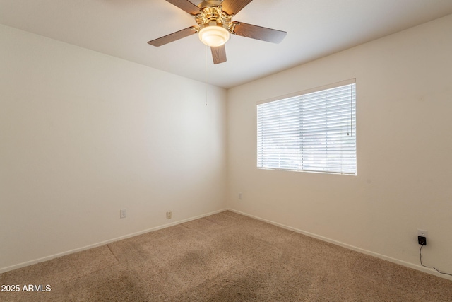 spare room with carpet floors, baseboards, and ceiling fan