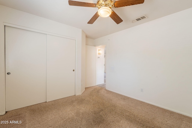 unfurnished bedroom with a ceiling fan, visible vents, carpet, and a closet