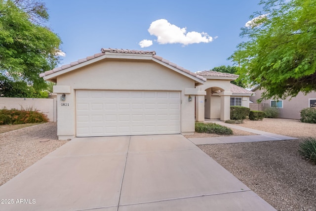 view of front of home featuring fence, an attached garage, stucco siding, concrete driveway, and a tiled roof