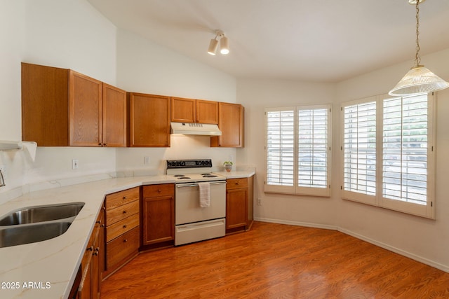 kitchen featuring brown cabinetry, a sink, light wood finished floors, white range with electric stovetop, and under cabinet range hood