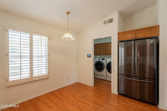 interior space featuring visible vents, cabinet space, wood finished floors, baseboards, and separate washer and dryer