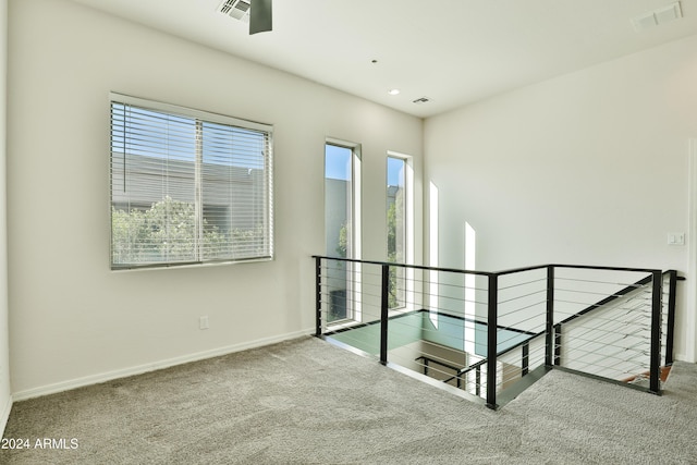 interior space with carpet flooring and multiple windows