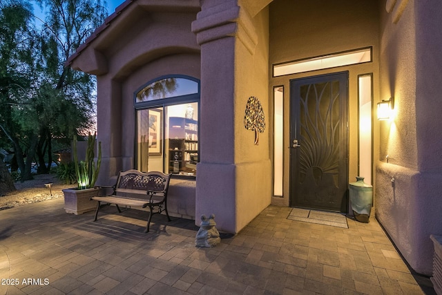 doorway to property featuring a patio and stucco siding