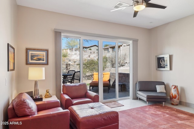 living area featuring visible vents, ceiling fan, baseboards, and light tile patterned floors