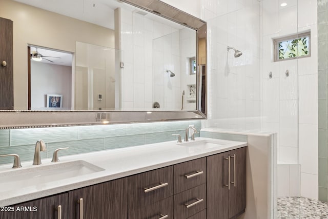 bathroom with tiled shower, a sink, backsplash, and double vanity