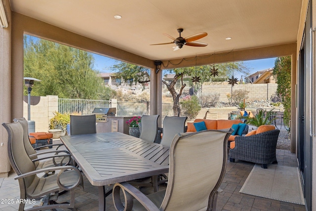 view of patio / terrace with outdoor dining area, area for grilling, ceiling fan, exterior kitchen, and a fenced backyard