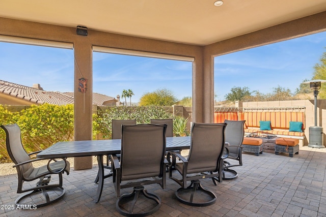 view of patio with a fire pit, outdoor dining area, and fence