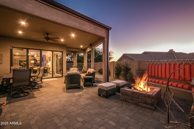 view of patio featuring ceiling fan, a fenced backyard, and an outdoor living space with a fire pit