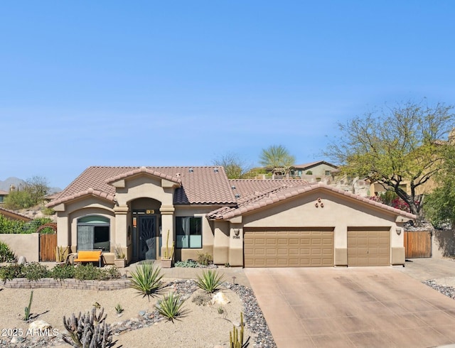 mediterranean / spanish-style home with driveway, a garage, a tile roof, fence, and stucco siding