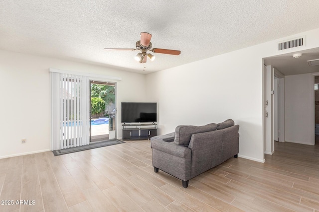 2031 W Gila Ln, Chandler, AZ 85224 - living area featuring light wood-style flooring, a ceiling fan, a textured ceiling, and baseboards