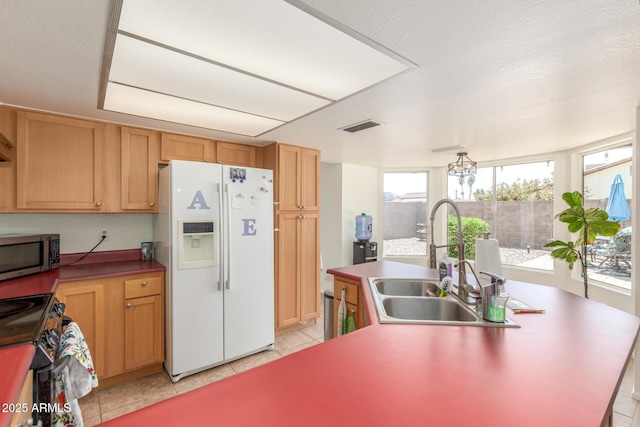 2031 W Gila Ln, Chandler, AZ 85224 - kitchen with white refrigerator with ice dispenser, stainless steel microwave, a sink, light tile patterned flooring, and range with electric cooktop