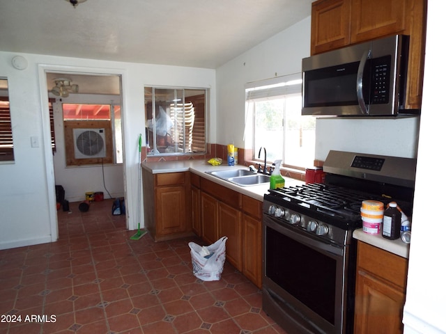 kitchen featuring appliances with stainless steel finishes, sink, and lofted ceiling